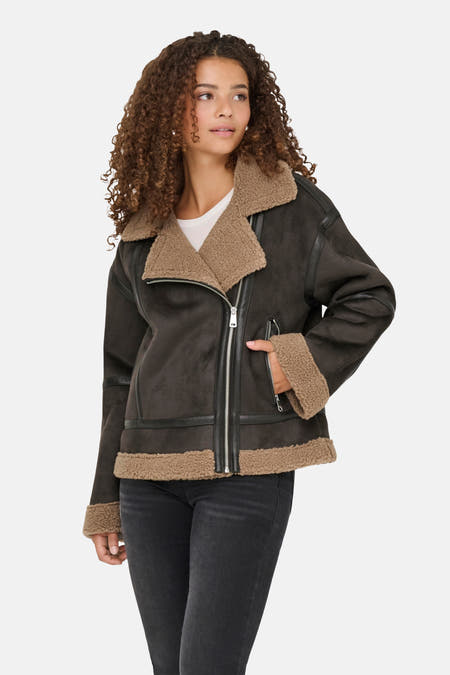 Manteau court brun d'ONLY, avec une doublure en fourrure de teddy sur le col et des jeans noirs.