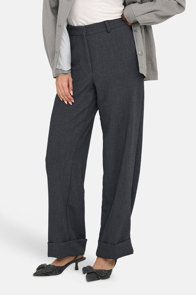 Pantalon gris de JDY, avec des jambes droites et un ourlet rabattu, associé à une chemise blanche et un manteau gris.