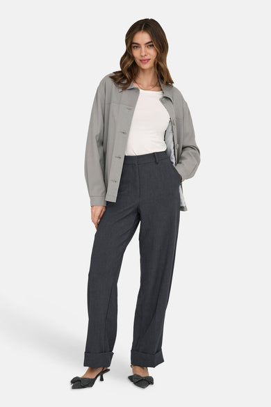 Grijze broek van JDY, met rechte pijpen en een omgeslagen zoom, gecombineerd met een wit shirt en een grijs jasje.

