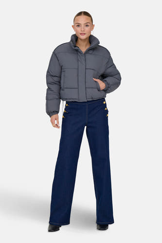 Manteau court gris d'ONLY, porté avec des jeans bleus marine à détails de boutons et des chaussures noires.