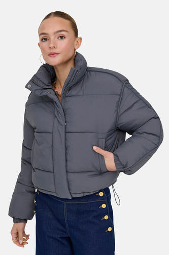 Gris, short jack de ONLY®, avec une col mont montante et des jeans bleu marine profond avec des boutons dorés.