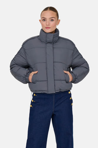 Manteau court gris d'ONLY, avec des poches et associé à un pantalon bleu foncé.