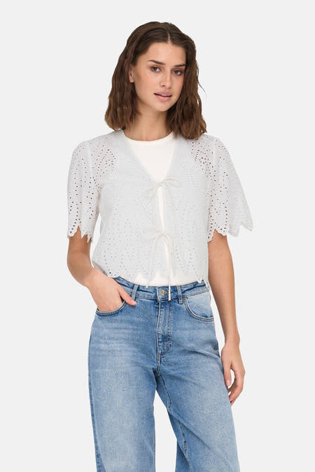 Blouse blanche à manches courtes de ONLY, ornée de broderie et associée à un t-shirt blanc et des jeans bleus.