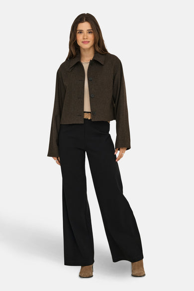 Manteau court brun d'ONLY, avec des manches longues, porté sur une chemise beige et un pantalon noir.