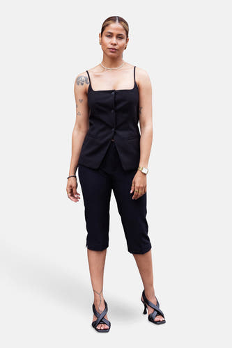 Pantalon noir de ONLY, avec une longueur trois-quarts, associé à un haut noir et des chaussures ouvertes à talons.