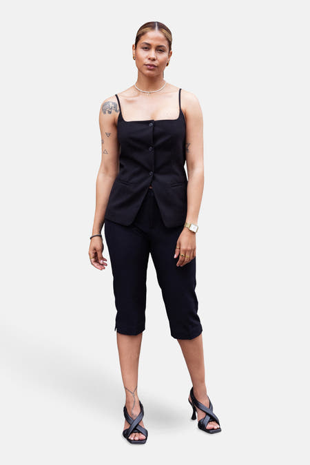 Pantalon noir de ONLY, avec une longueur trois-quarts, associé à un haut noir et des chaussures ouvertes à talons.