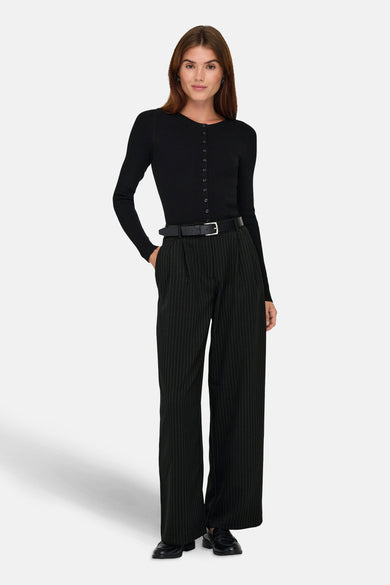 Pantalon noir de ONLY, avec une rayure blanche et des jambes larges, combiné à un haut noir et une ceinture.