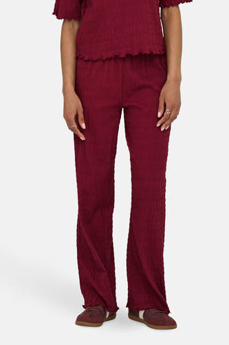Pantalon ONLY de Bordeaux, avec une texture pliée et des jambes fuselées.