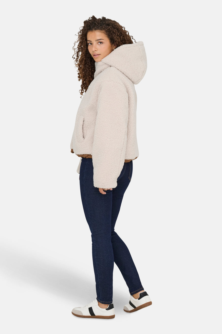 Blouson écru ONLY, avec capuche, associé à des jeans foncés et des sneakers blanches.