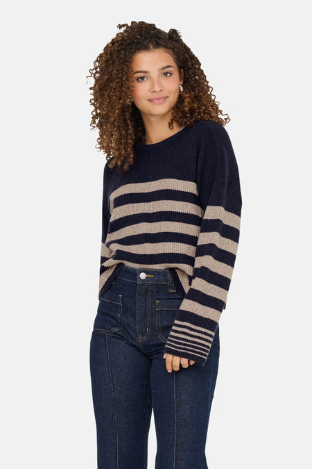 T-shirt bleu avec col rond de ONLY, avec des rayures beige et un jeans foncé.