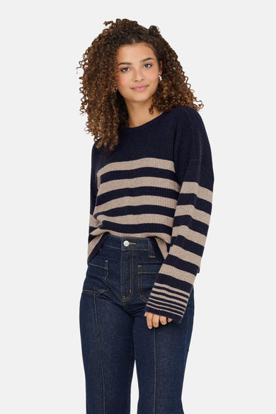 T-shirt bleu avec col rond de ONLY, avec des rayures beige et un jeans foncé.