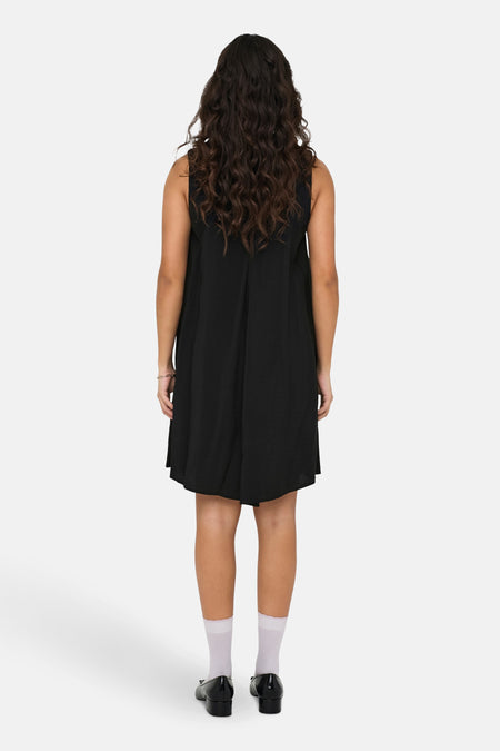 Robe noire sans manches de JDY, vue de derrière avec des chaussettes blanches et des chaussures noires.