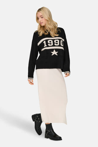Pull-over noir à col rond de ONLY®, doté du nombre 1990 et d'une étoile, combiné avec une longue jupe et des bottes.