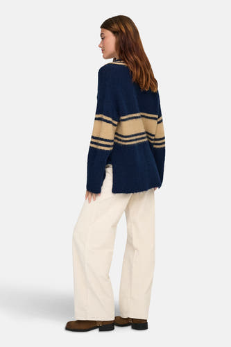 Pull rayé bleu d'ONLY®, avec des manches longues, porté avec un pantalon corduroy couleur crème et des bottes brunes.