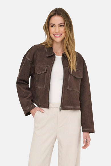Veste courte brune d'ONLY, avec des boutons contrastants et portée sur un chemisier blanc et un pantalon beige.