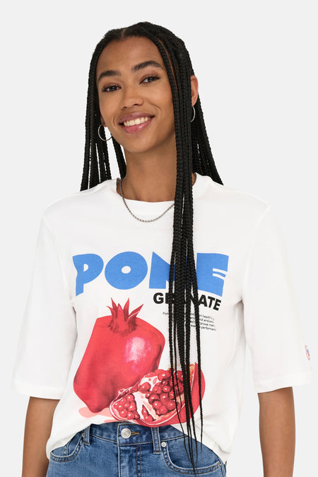 T-shirt blanc à manches courtes de ONLY®, avec un imprimé d'une grenade, porté avec une chaîne en argent et des boucles d'oreilles.