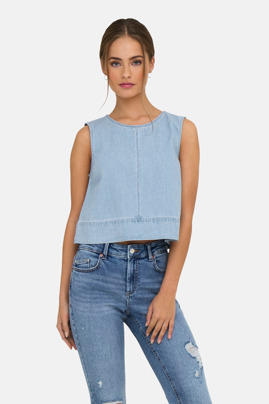 Vrouw, lichtblauwe jeans, denim top, staand.