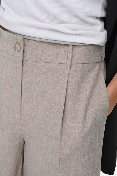 Short beige ONLY® avec texture lin, fermeture à boutons et plis, porté avec un haut blanc côtelé et un blazer noir.