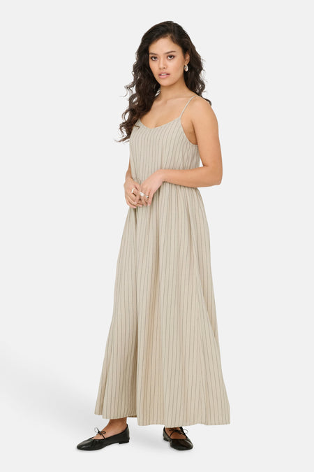 Robe beige sans manches de JDY, avec des fines rayures verticales et des baskets noires.