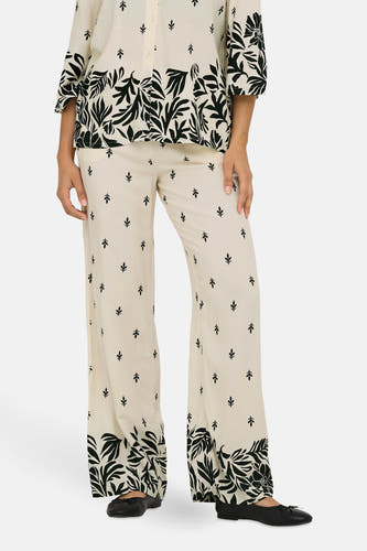 Pantalon écru de JDY avec un motif feuille et des bords larges, porté avec une blouse coordonnée.