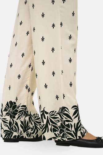 Pantalon écru de JDY avec une subtile impression de feuille et des jambes larges et fleuries.
