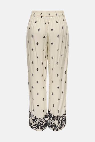 Pantalon écru de JDY avec de petits motifs de feuilles et un large bord de fleurs sur les jambes du pantalon.