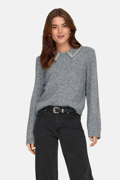 Sweat-shirt gris à col rond de JDY, avec un collier en perles, porté avec des jeans noirs et une ceinture.