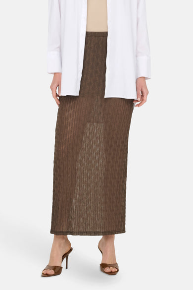 Long manteau brun d'ONLY, avec une texture tissée, associé à un chemisier blanc et des baskets brunes.