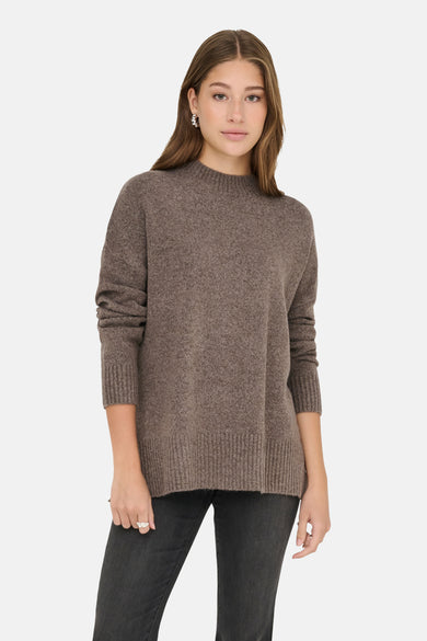 Pull marron avec col rond de ONLY, à longues manches, porté avec des jeans noirs et des boucles d'oreilles argentées.