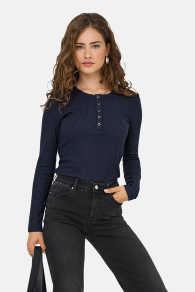 T-shirt bleu à manches longues de ONLY, avec un détail de boutons et porté avec des jeans noirs.