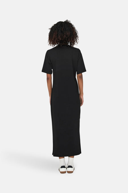 Robe noire à manches courtes de ONLY, avec une longueur jusqu'aux chevilles et des baskets avec des chaussettes.