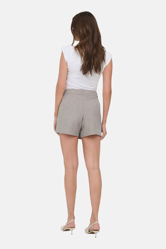 Short beige ONLY® avec texture légère, porté par un mannequin avec un haut blanc et des talons.