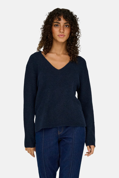 T-shirt à col V bleu de JDY, avec longues manches, associé à des jeans bleus marine.