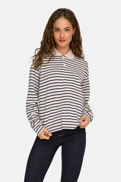 Polo écru à longues manches de JDY, avec des rayures bleues et des longues manches, porté avec un jeans foncé.