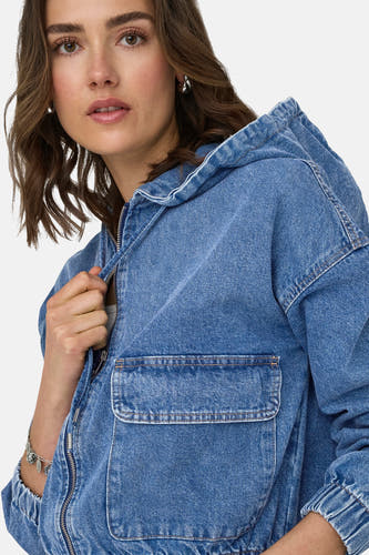 Jean en blauw denim ONLY, avec capuchon et fermeture éclair argentée.