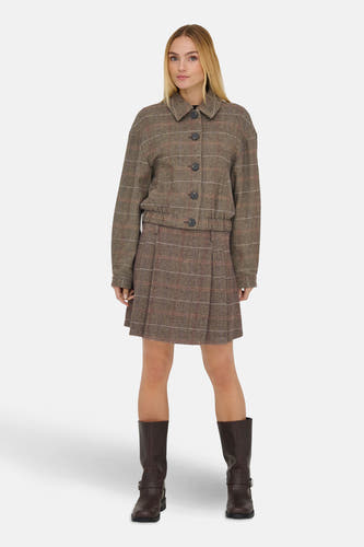Manteau court brun d'ONLY, avec des boutons et un motif à carreaux, associé à une jupe coordonnée et des bottes brunes.