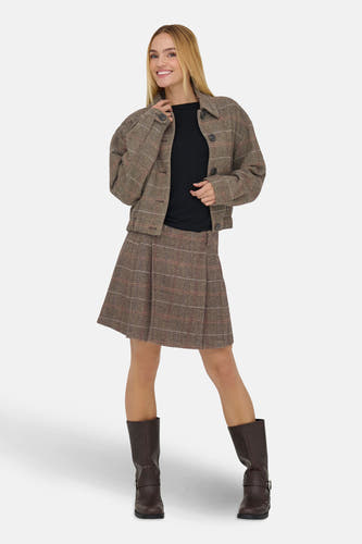 Manteau court brun d'ONLY, avec un motif de carreaux, porté sur une chemise noire et une jupe coordonnée, avec des bottes brunes.