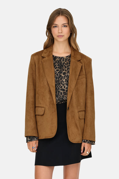 Blazer beige de ONLY®, avec une texture douce en suède, porté sur un haut à imprimé animal et une jupe noire.