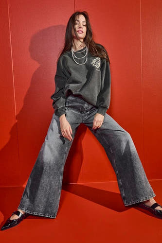 Jean gris large d'ONLY, avec un lavage délavé et associé à un pull gris et une chaîne de perles.