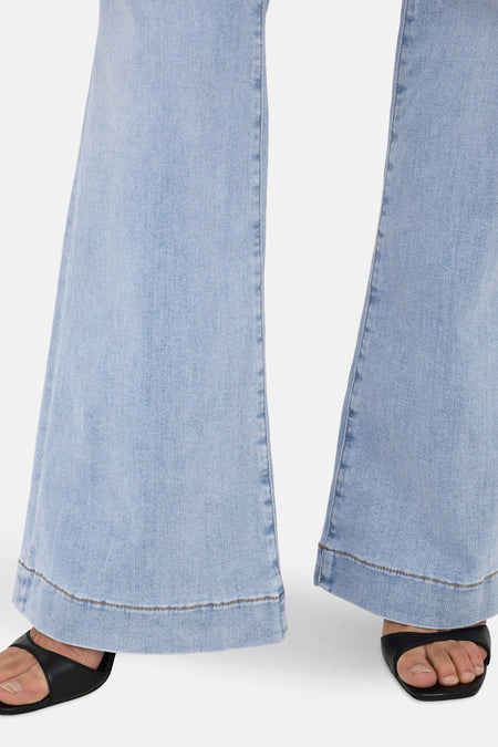 Jean flare bleu clair ONLY, avec des détails de zoom et associé à des sandales noires.