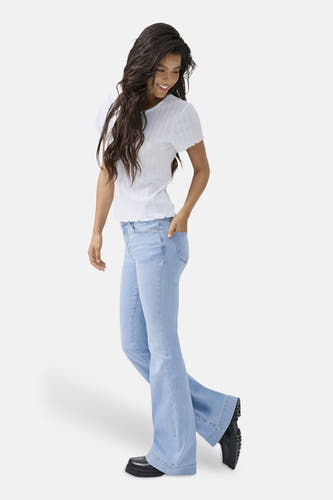 Jean évasé bleu clair de ONLY, avec jambes larges et porté avec un t-shirt blanc.