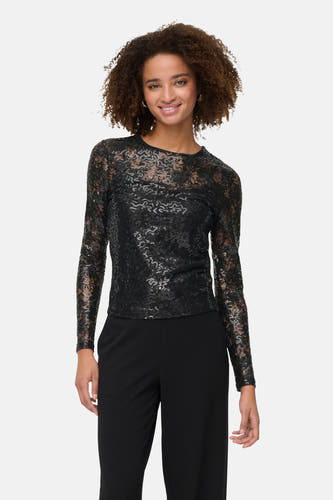 Blouse noire à manches longues de ONLY, avec un motif subtil et portée avec une jupe noire à larges plis.