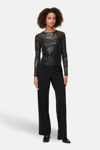 Zwarte blouse met lange mouwen van ONLY, met een subtiel patroon en gedragen met zwarte broek met wijde pijpen.