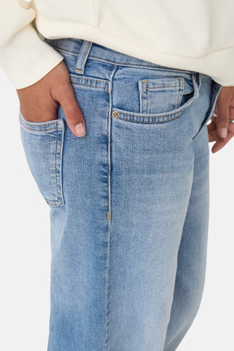 Jean bleu clair large d'ONLY, avec une main dans la poche et des détails subtils.