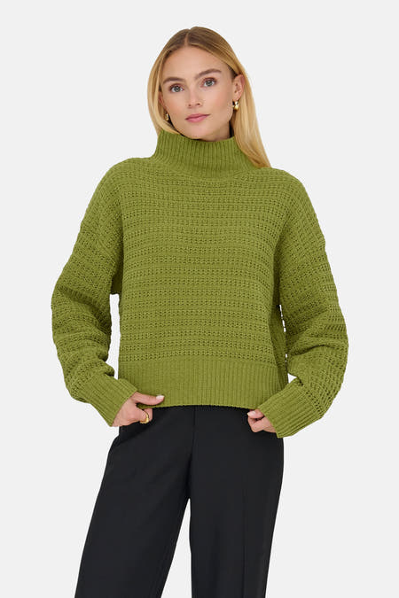 Gilet vert de ONLY, avec des manches longues et une texture tricotée épaisse, associé à un pantalon noir large et ample.