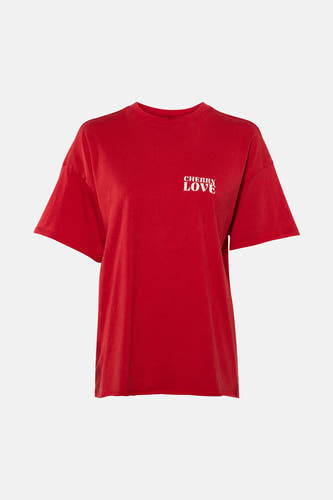 T-shirt rouge à manches courtes de ONLY®, avec "CHERRY LOVE" imprimé en blanc, à combiner avec un jean bleu et des baskets.