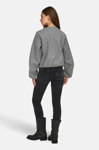 Manteau court gris de JDY, vu de derrière, avec des jeans noirs et des bottes noires.
