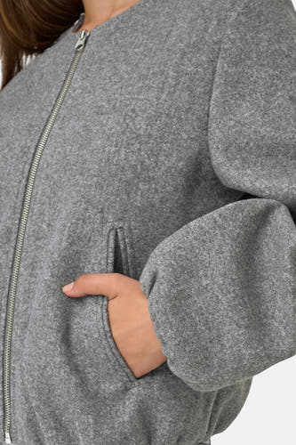 Manteau court gris de JDY, avec une fermeture éclair argentée et un poche poitrine, détail.