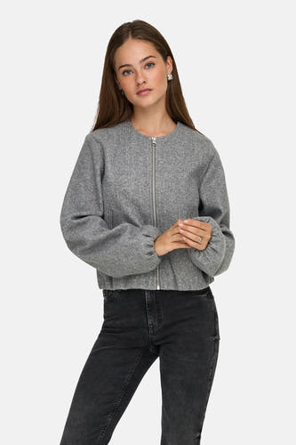 Manteau court gris de JDY, avec des manches longues et une fermeture éclair argentée, porté avec un jean noir.