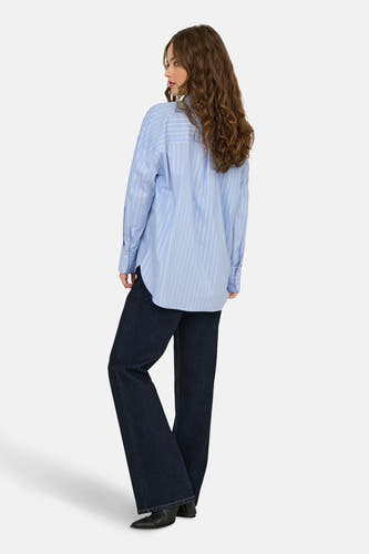 Blouse à rayures bleues avec longs manches de JDY, vue de derrière, associée à des jeans foncés et des bottes.